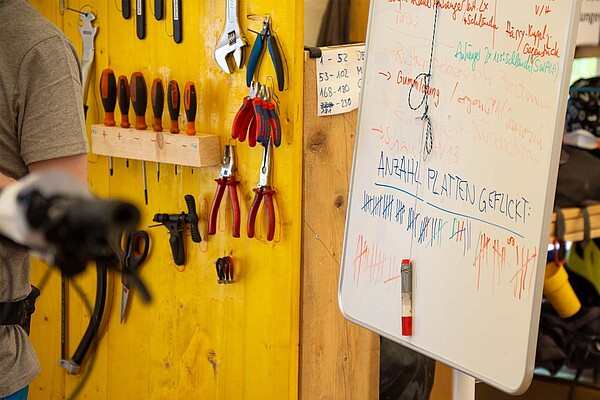Eine Velostadt mitten im Goms. Werkzeuge hängen an einer Wand.