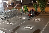 Frisch markierte Parkplätze für Cargobikes neben Einkaufswagen Station in der Nacht