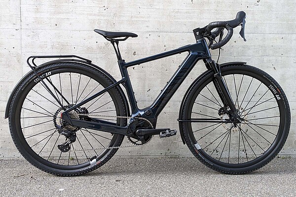 Canyon GrizlOn CF Daily im Test. E-Gravelbike mit Federgabel vor einer Betonmauer.