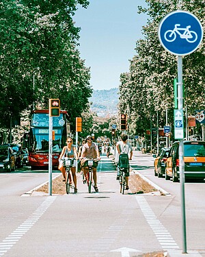 Asoziale Strassen. Radfahrende auf einem schmalen Velostreifen zwischen zwei Autofahrspuren.