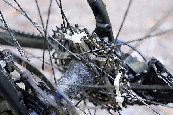 Fahrrad Panne mit Kabelbinder flicken. Eine Fahrradkassette wird mit Kabelbindern zusammengehalten.