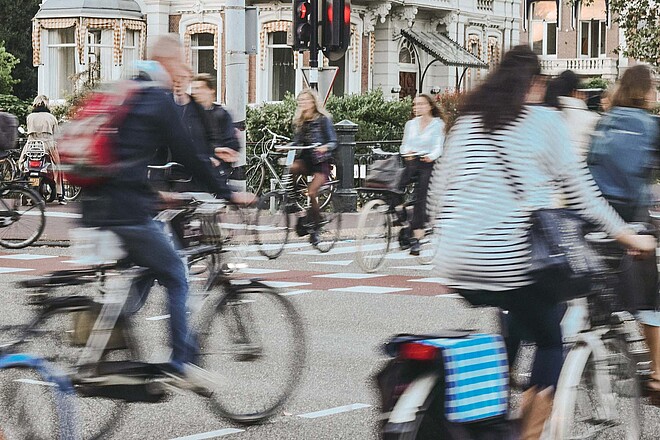 Das Astra hat einen Veloknigge herausgegeben. Strassenkreuzung mit vielen Personen auf Fahrrädern.