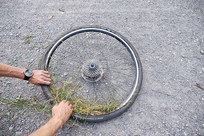 Tipps Fahrrad Panne unterwegs flicken. Fahrradreifen mit Gras auffüllen.