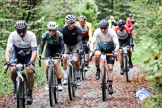 Gravel Ride & Race Bern. Frauen und Männer auf Gravelbikes im Wald.