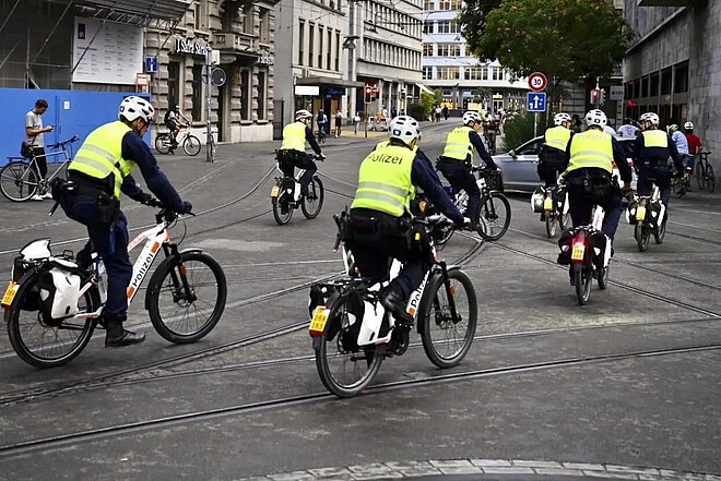 Repression an der Critical Mass in Zürich. Polizisten in Leuchtwesten fahren auf E-Bikes in der Stadt Zürich.