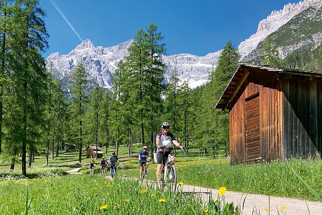 Portrait des Reiseanbieters Twerenbold. E-Bike-Fahrerin in den Bergen.