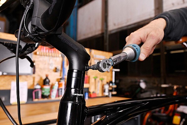 Eine Person hält einen Drehmomentschlüssel in der Hand.