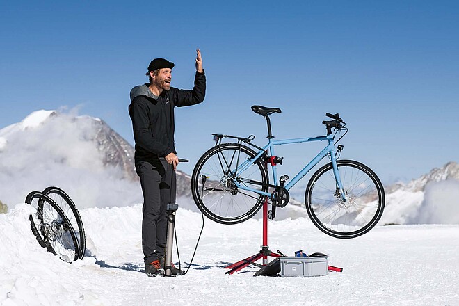 Testlabor auf 3456 Meter über Meer. (Foto: Mirjam Graf) Ein Mann steht mit einem Fahrradständer im Schnee