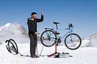 Ein Mann steht mit einem Fahrradständer im Schnee