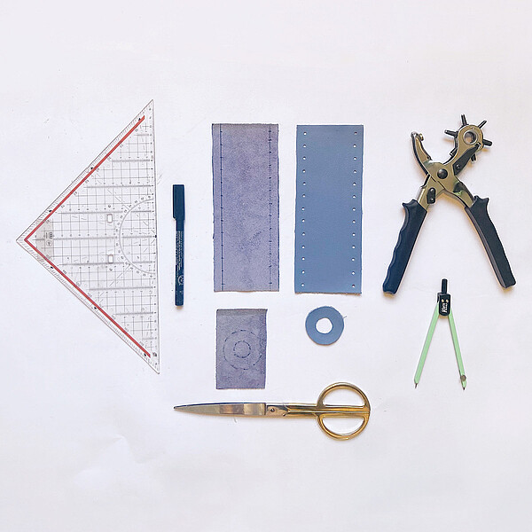 DIY-Velojournal Anleitung für Kerzenständer: Auslage Lederteile, Lochzange, Geodreieck und Schere vor weissem Hintergrund