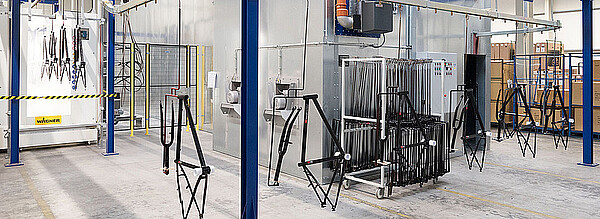 Dutech Holding kauft Prophete und Cycle Union. Fahrradrahmen hängen in einer Lackierstrasse.