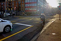 Velofahrerin steht im Velosack genannten Aufstellbereich für Velos.