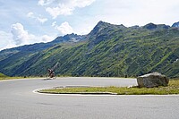 Ein Mann fährt mit dem Rennrad eine Passstrasse hoch