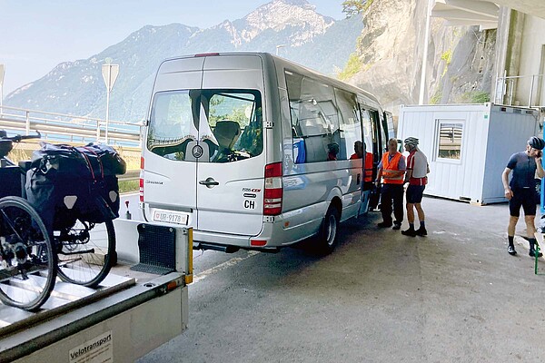 Velofahrverbot Axenstrasse. Shuttlebus mit Anhänger, auf dem Fahrräder stehen.