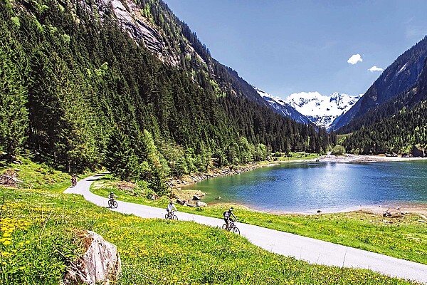 Radfahrer in den Bergen, im Hintergrund ein See