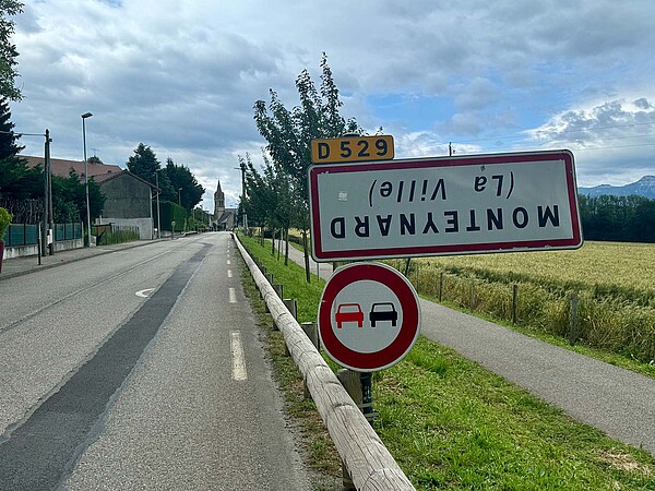 umgedrehtes Ortsschild in Frankreich. 