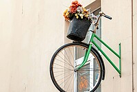 Deloitte Studie Nachhaltigkeit Fahrradindustrie DACH. Ein grünes Fahrrad hängt an einer Mauer.