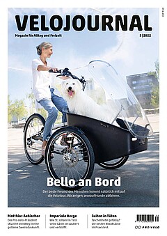 Velojournal 5-2022. Eine Frau mit weissem Shirt fährt ein Lastenrad, imdem vorne ein weisser Wuschelhund sitzt.