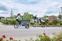 Eine Frau und ein Mann auf Cargobikes mit Neigetechnik.