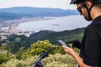 Canyon Smartphone App. Ein Biker hält sein Smartphone in der Hand.