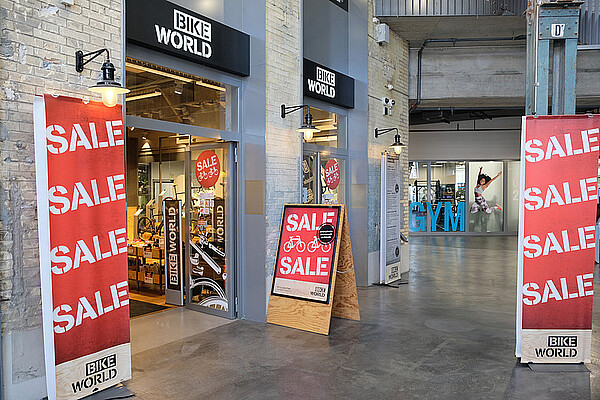 Migros will sich von Bike World trennen. Fahrradgeschäft mit Sale-Schildern vor dem Laden.