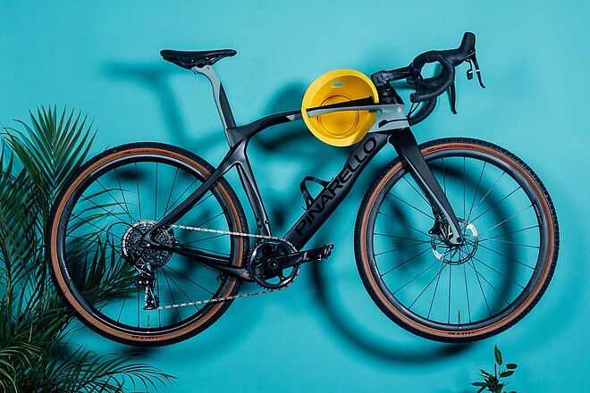 Cycloc Wandhalterung für Fahrräder. Ein Fahrrad hängt an einer blauen Wand.