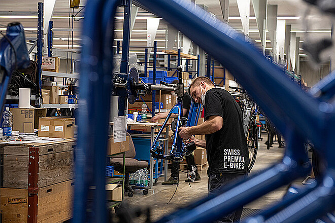 Flyer entlässt ein Drittel der Belegschaft. Ein Mann montiert ein E-Bike. 