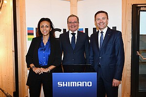 Drei Personen stehen hinter einem Rednerpult mit der Aufschrift Shimano.