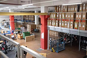 Veloplus Velos und Zubehör. Lagerhalle mit Fahrradkartons.