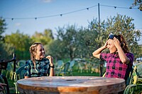 Zwei Frauen sitzen im Garten an einem Tisch