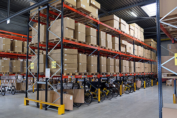 Marktbulletin Velohandel Schweiz. Hochregal mit Fahrradkartons gefüllt.