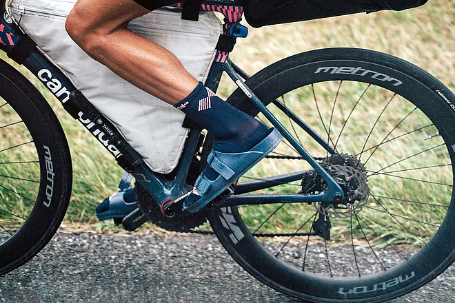 Ein Radsportler fährt mit Sandalen auf dem Rennrad