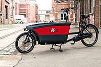 Mooinz Bikesharing Chur. Lastenvelo mit roter Box.