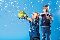 Als Familie lassen sich auf zwei  Rädern schöne Erlebnisse sammeln. Kinder spielen mit Seifenblasen.