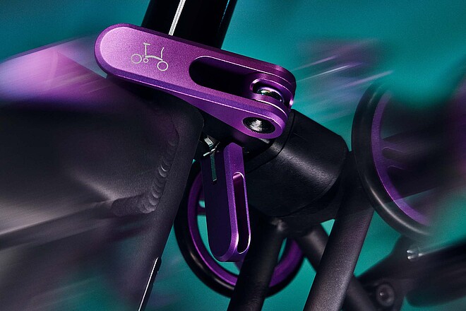 Violetter Schnellspanner für den Sattel eines Fahrrads von Brompton. 