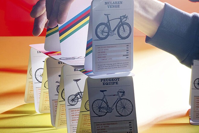 Ein Velokilometer kostet mehr, als man denkt. Kartenhaus mit Quartettkarten, auf denen Velos zu sehen sind.
