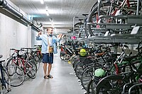 Ein Mann nimmt sein Fahrrad aus einem Fahrradkeller.